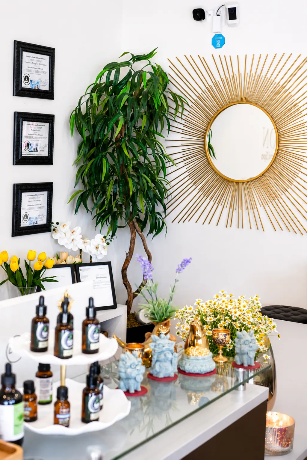 Reception desk with certificates, essential oils, and fresh flowers