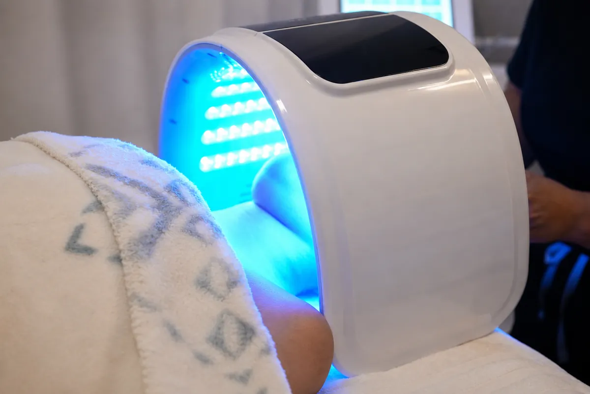 LED light-therapy dome treatment over a resting client